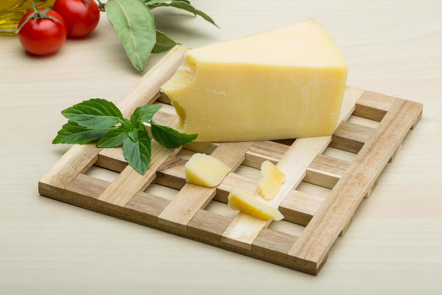 Parmesan cheese on wooden board and wooden background photo