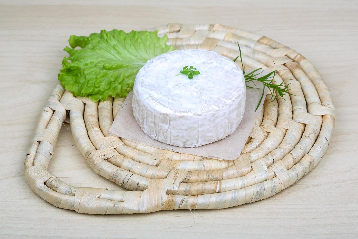 Brie cheese on wooden board and wooden background photo