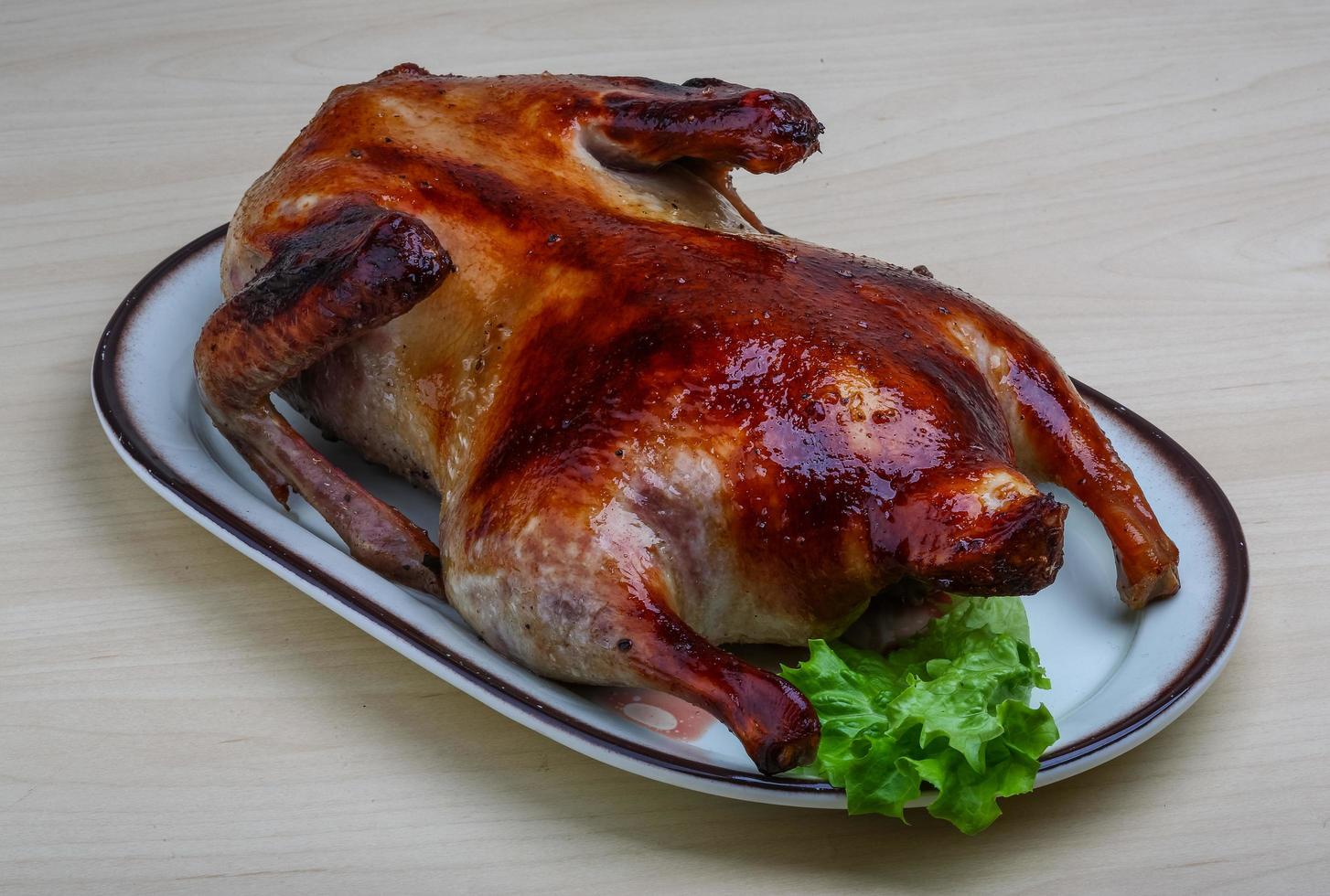 pato asado en el plato y fondo de madera foto