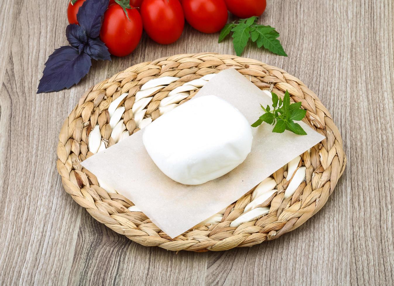 Mozzarella cheese on wooden board and wooden background photo