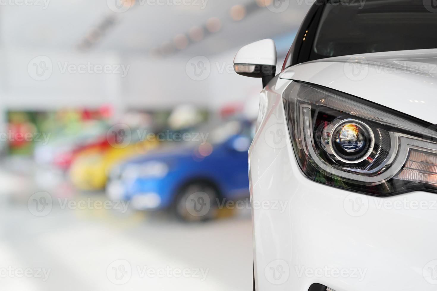 primer plano de la parte delantera del coche nuevo en el fondo de la sala de exposición foto