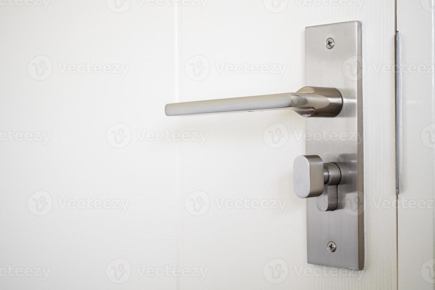 Modern door handle with on white door photo
