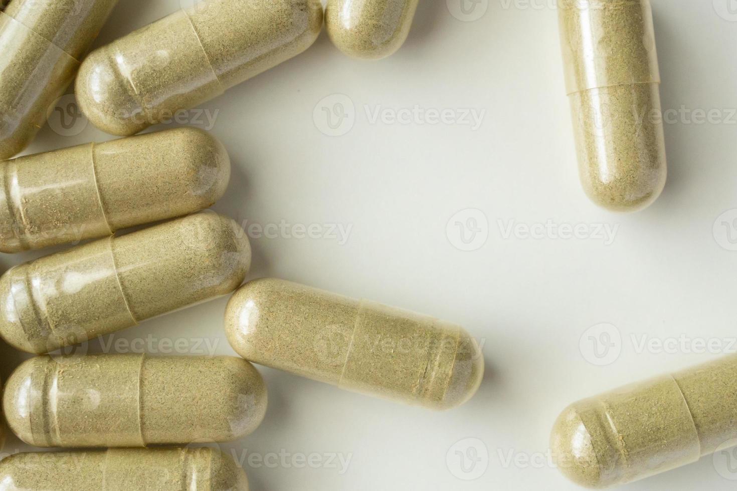 Herbal medicine capsules on white background photo