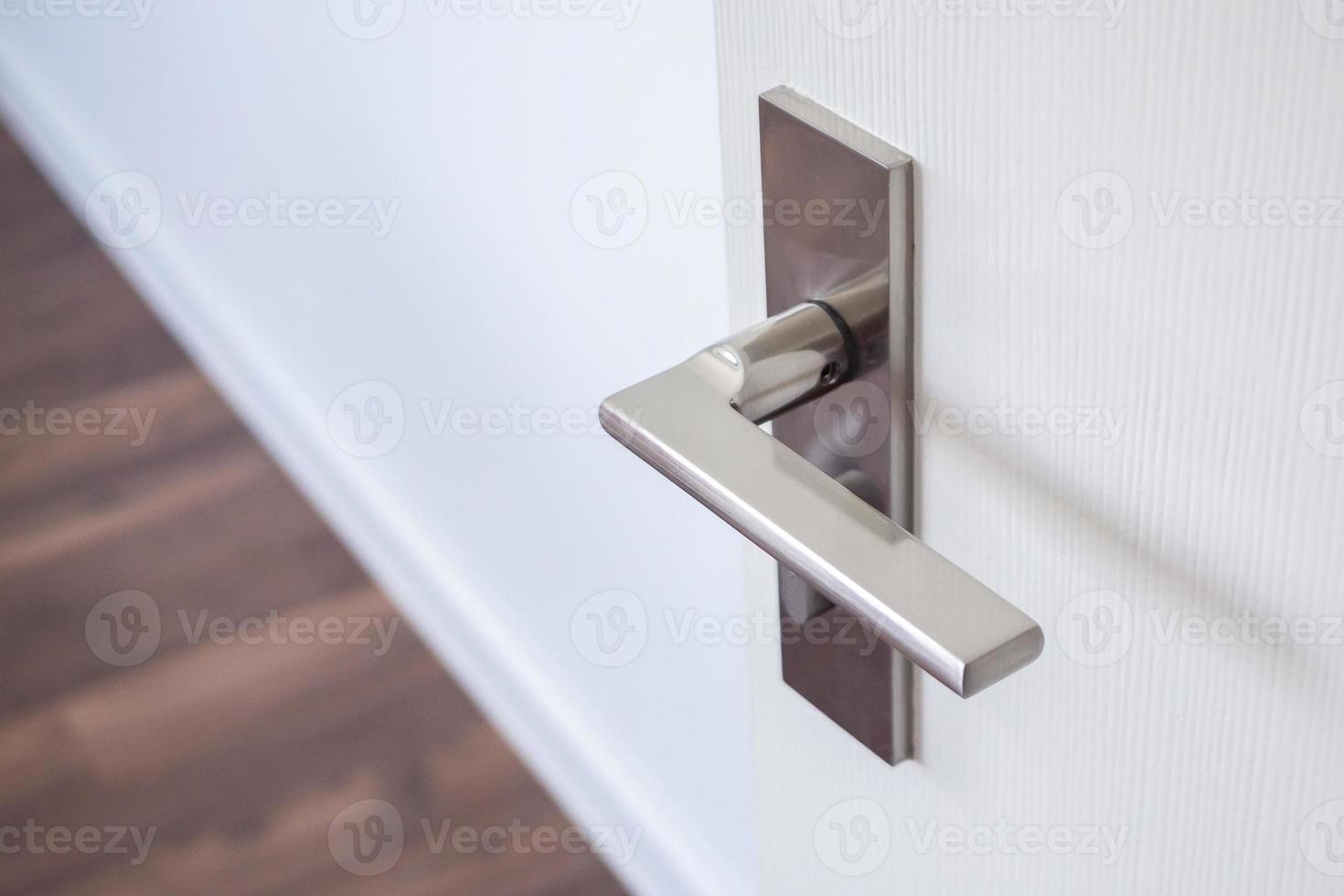 Modern door handle with on white door photo
