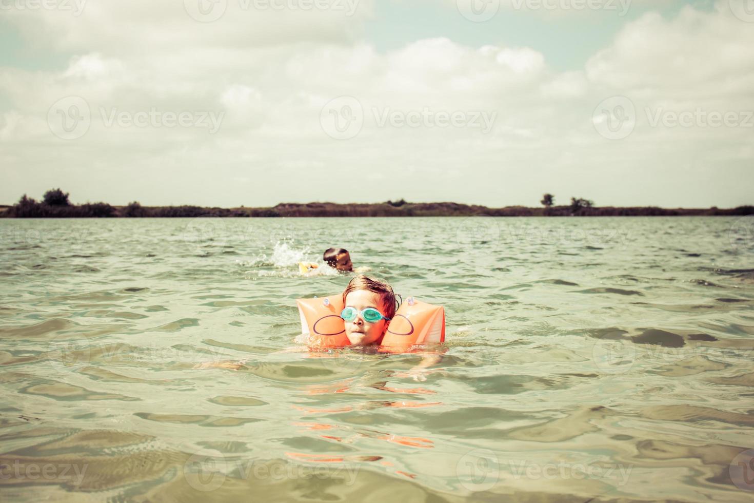 Small boys swimming in the water in summer day. photo