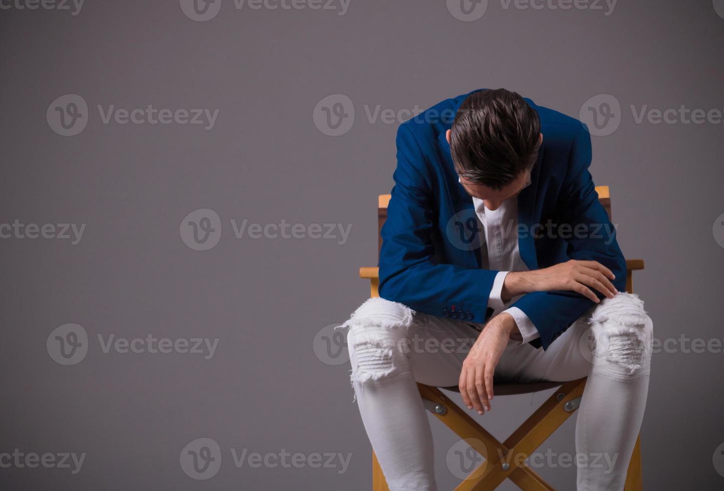 Sad man sitting in a chair and feeling depressed. photo