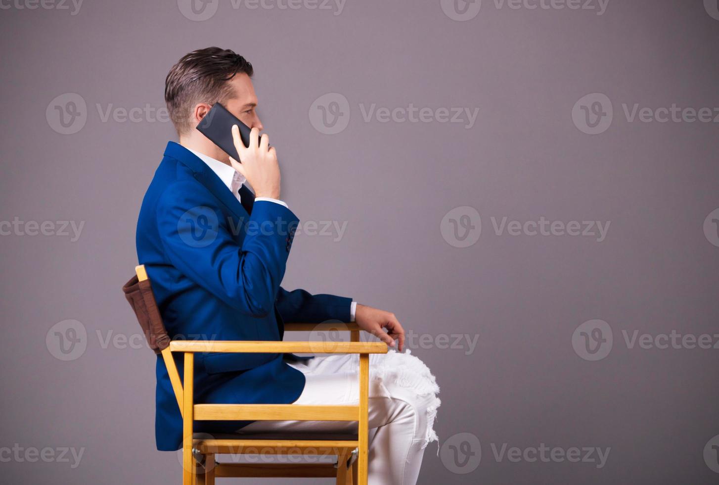 Side view of of entrepreneur talking on the phone against gray background. photo