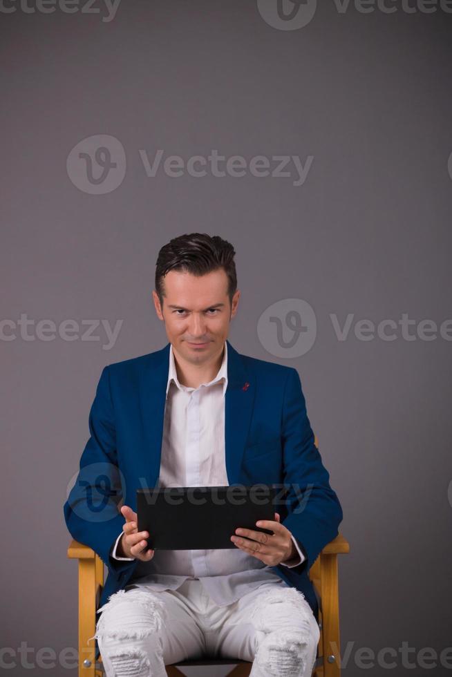 Smiling businessman using touchpad and looking at camera. photo