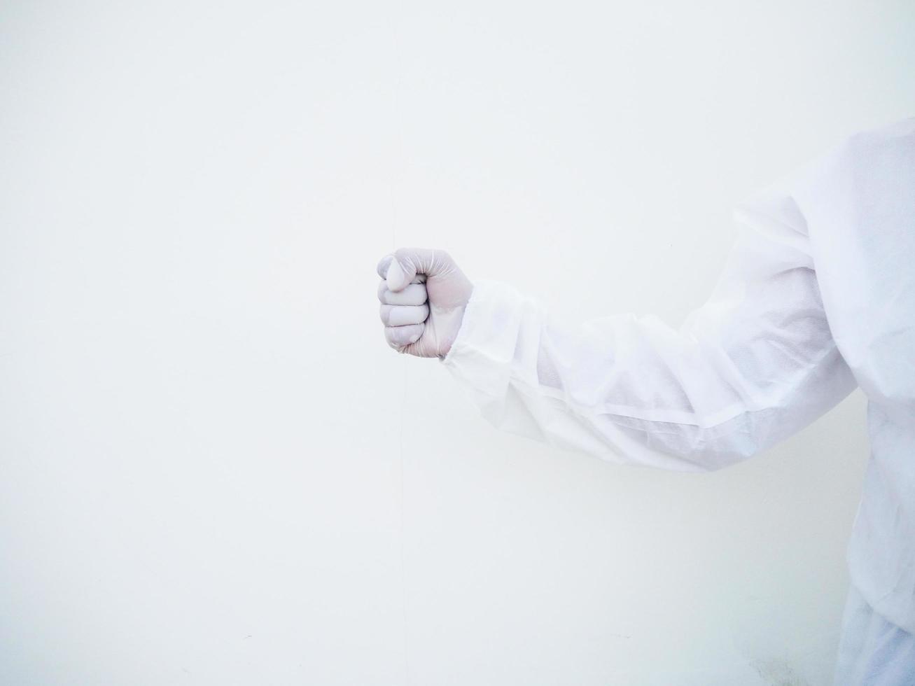 Asian doctor or scientist in PPE suite uniform showing clenched fist for hit something for text or design on a white background. coronavirus or COVID-19 concept photo