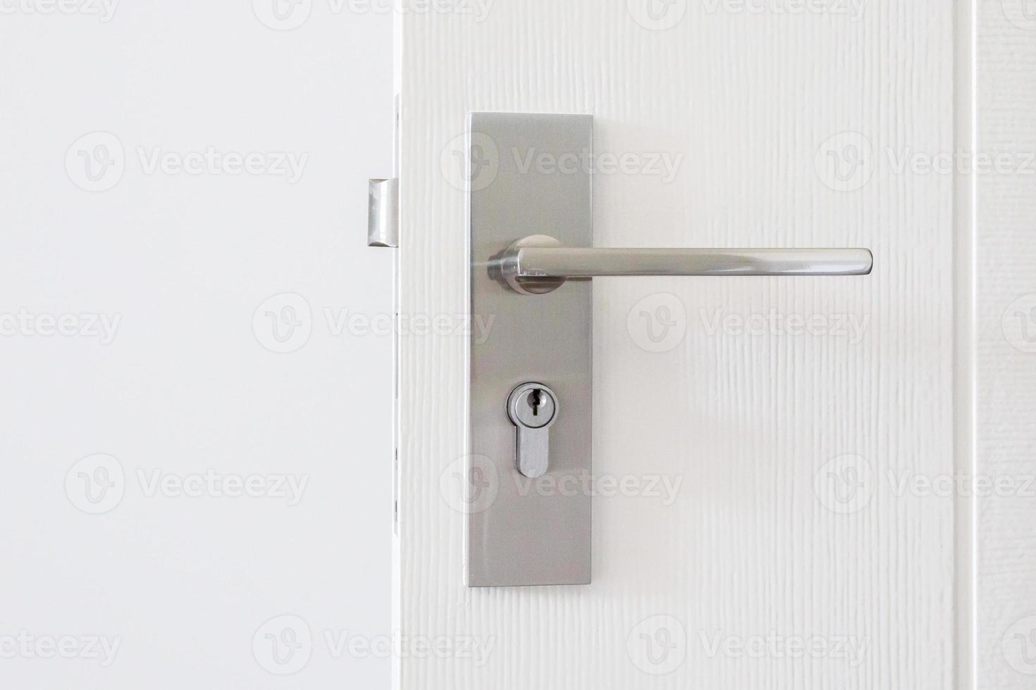 Modern door handle with keyhole on white door 12739147 Stock Photo at