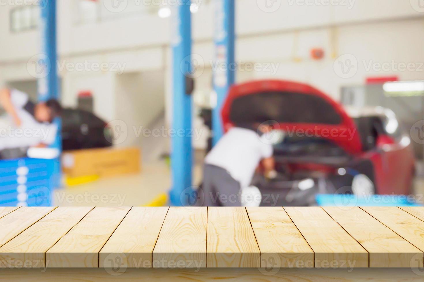 Empty wood table top with car service centre auto repair workshop blurred background photo