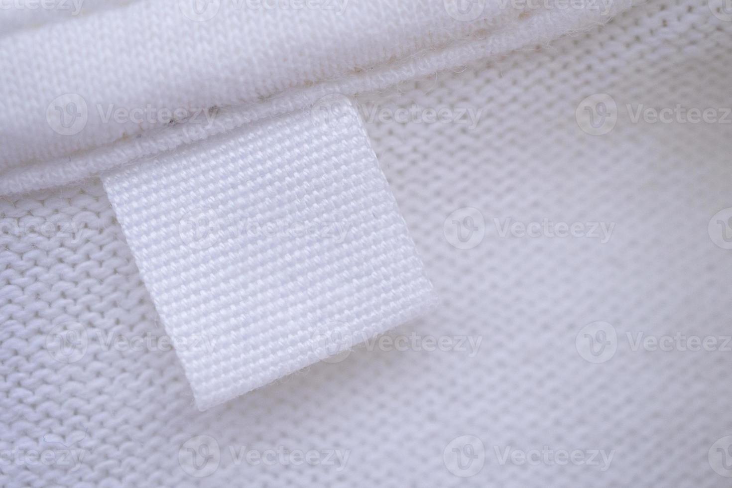 Blank white clothes label on new shirt background photo
