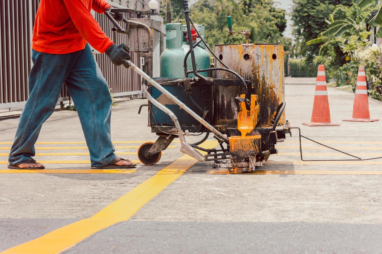 Road worker paint traffic lines on asphalt road surface. photo