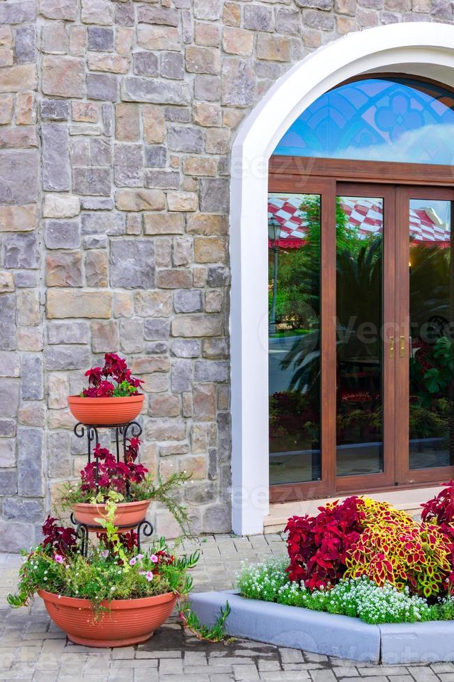 patio. pared de ladrillo con ventana grande decorada con hermosas flores foto