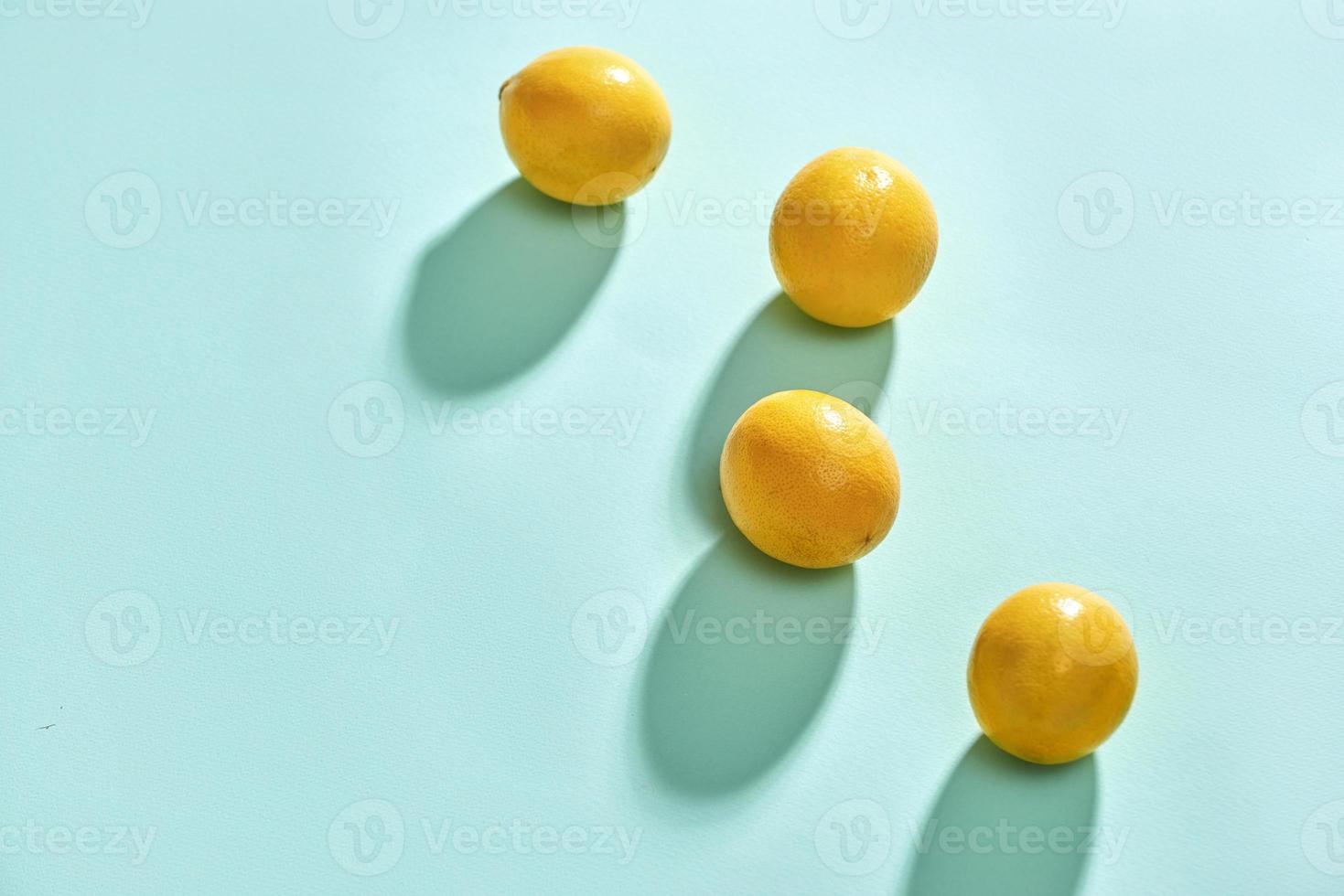 Fresh delicious lemon isolated on blue background. Creative minimalistic food concept. photo