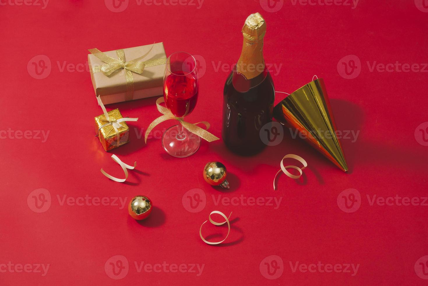 Champagne and Christmas ornaments on red table  background photo