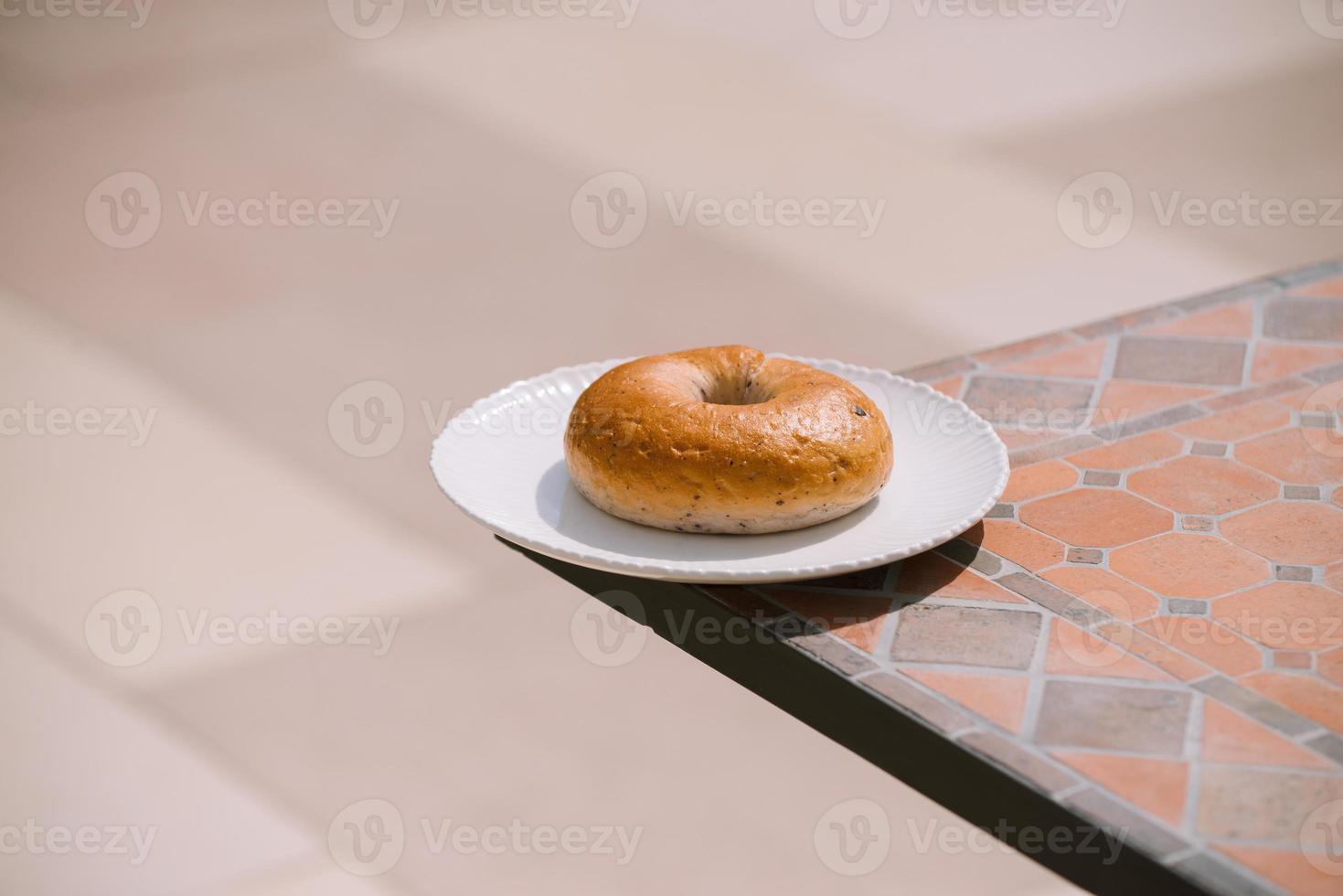 desayuno mañana soleado clima cálido con donut en plato blanco sobre fondo de mesa. buen humor vista horizontal foto