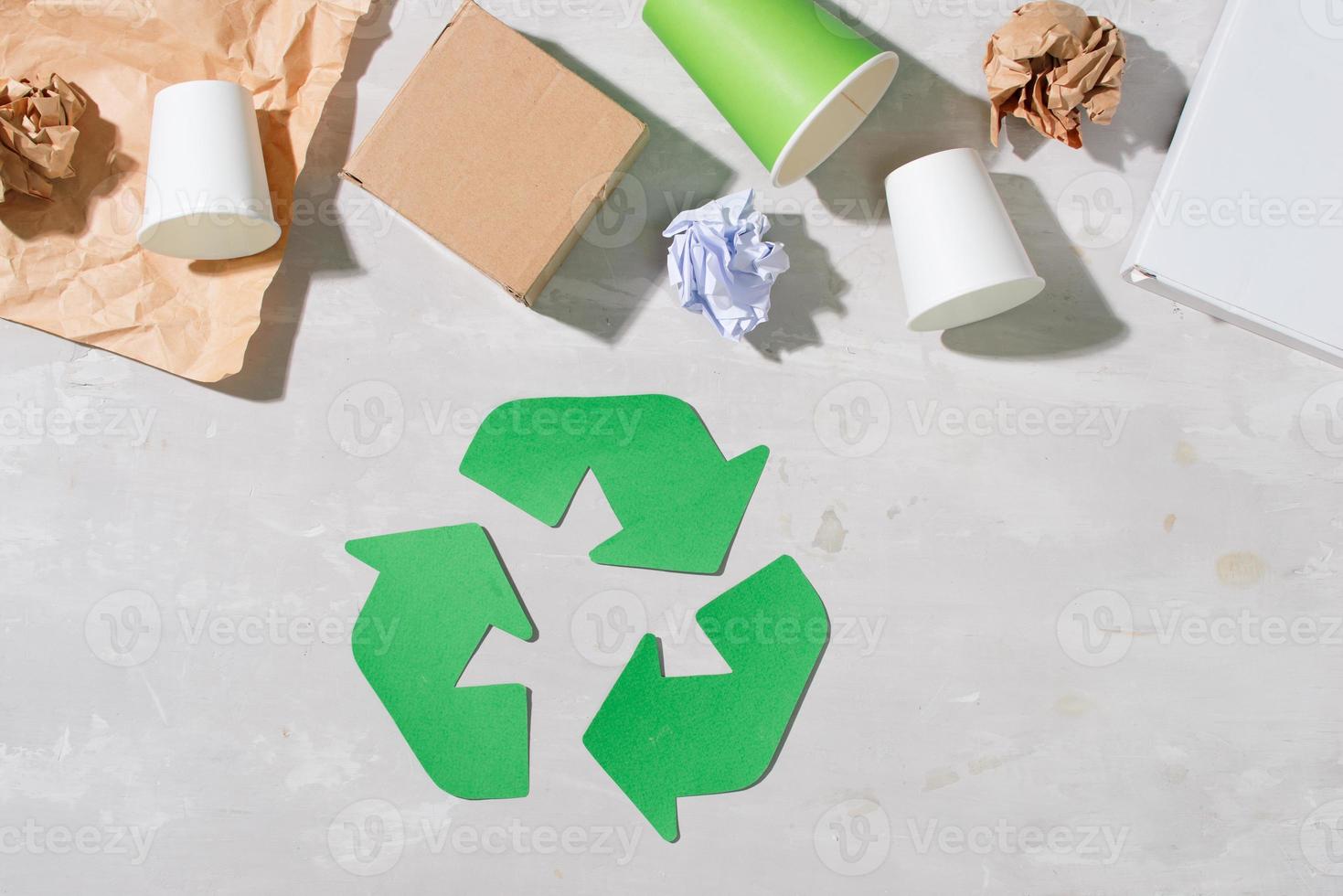 recycling symbol with waste on wooden background top view photo