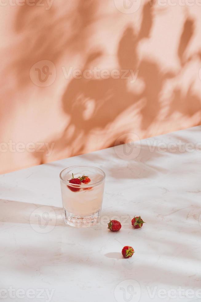 Summer juice with fresh raspberries in a glass on a light background photo