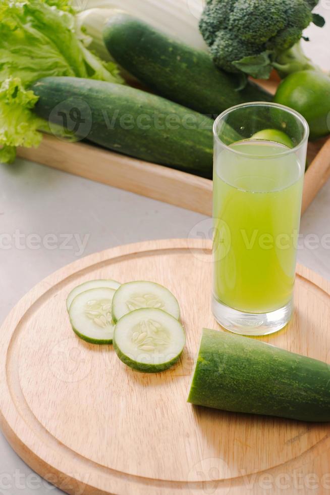 Vegan diet food. Detox drinks. Freshly squeezed juices and smoothies from vegetables. On white background, wooden tray, ingredients. Copy space photo