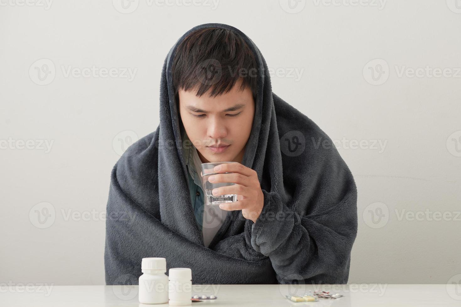 a man wrapped in a warm blanket basks on a light background photo