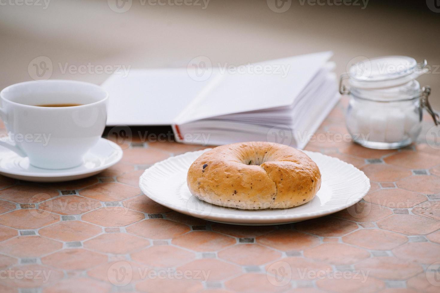 café, un buen libro y pan para una buena mañana en cafetería foto