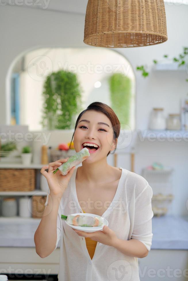 woman eating healthy spring roll photo