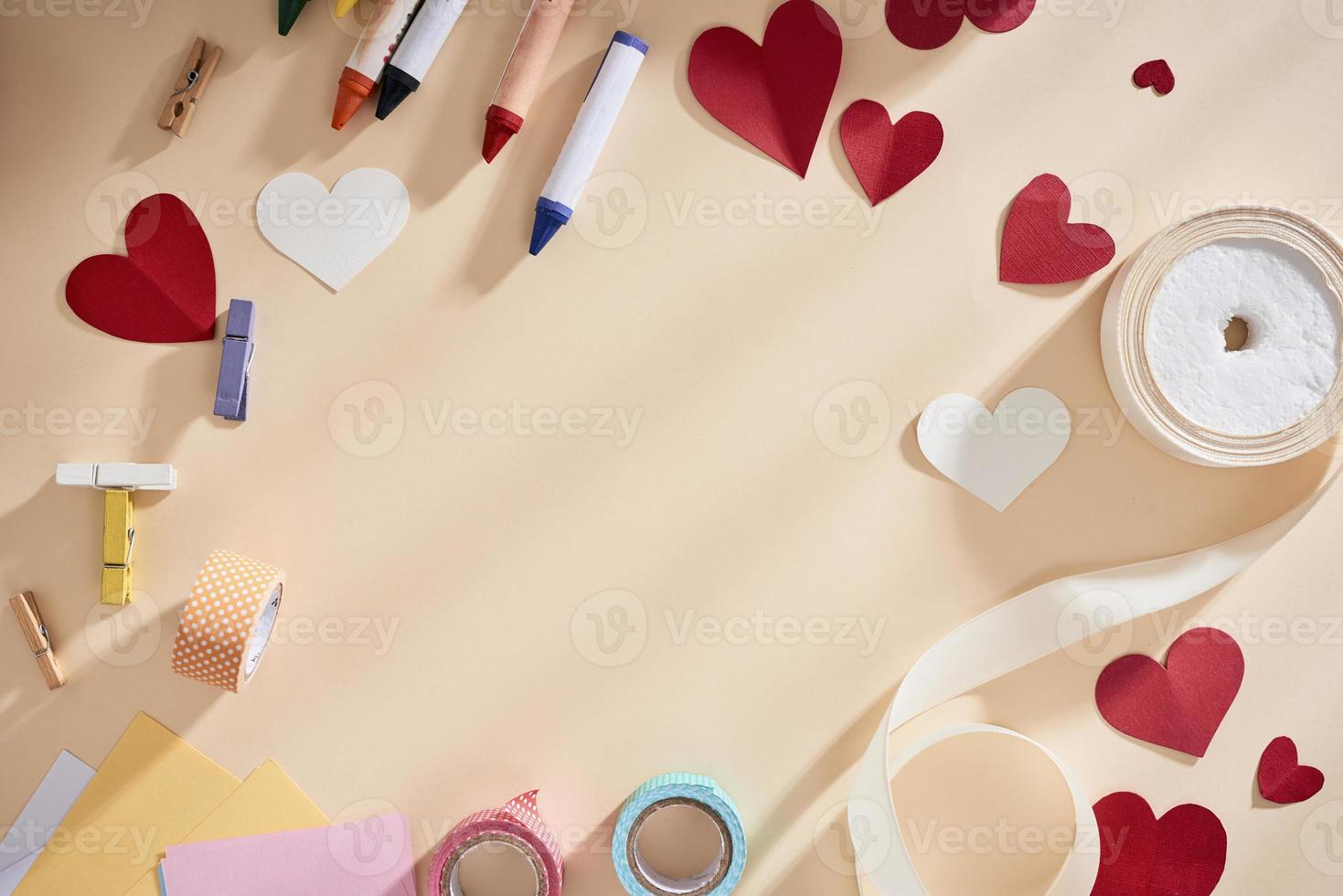 marco con espacio de copia para tarjeta de felicitación con símbolos de amor, corazones y cintas sobre fondo biege foto