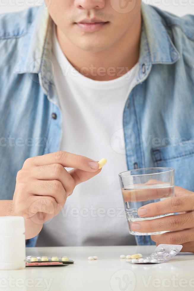 Man taking his pills on couch in the living room 12746179 Stock Photo