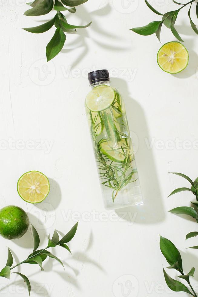 Health care, fitness, healthy nutrition diet concept. Fresh cool lemon rosemary infused water, cocktail, detox drink, lemonade in a glass jar. Light top view flat lay background photo