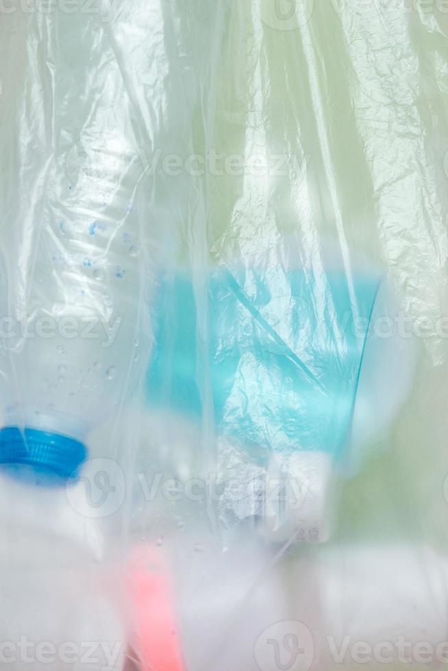 Plastic bag filled with household waste isolated on white background. photo