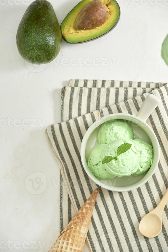 homemade organic avocado ice cream, with ice cream cones. On a grey