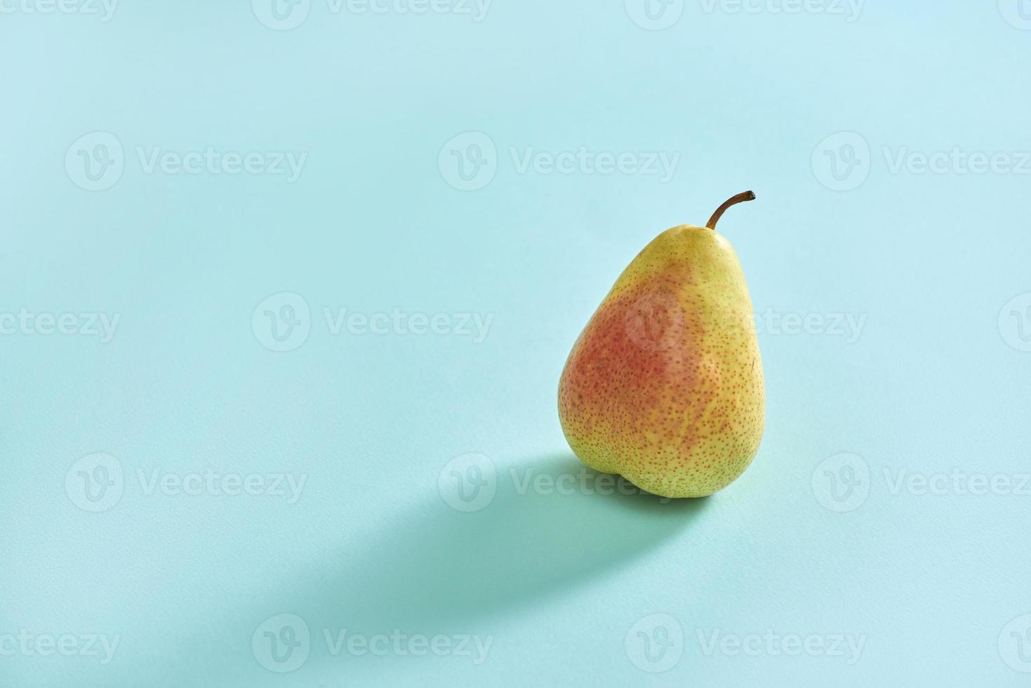 Pear decoration stock images. Yellow pear on a blue background. Pear home decor. photo