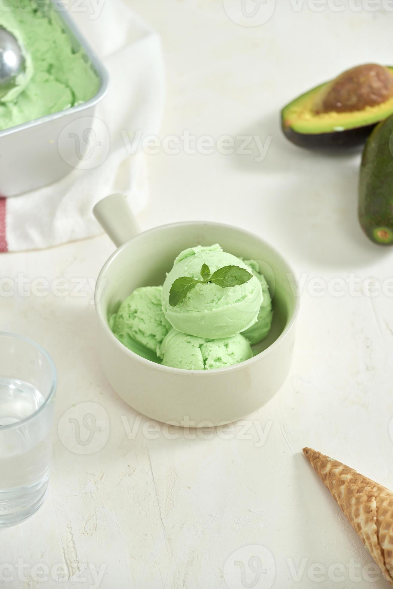 homemade organic avocado ice cream, with ice cream cones. On a grey