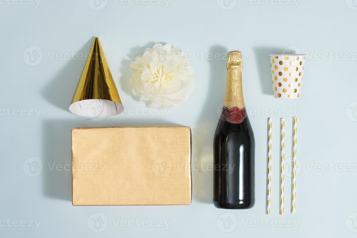 Flat lay Christmas or party background with gift boxs, champagne bottle, bows, decorations and wrapping paper in gold . Flat lay, top view photo