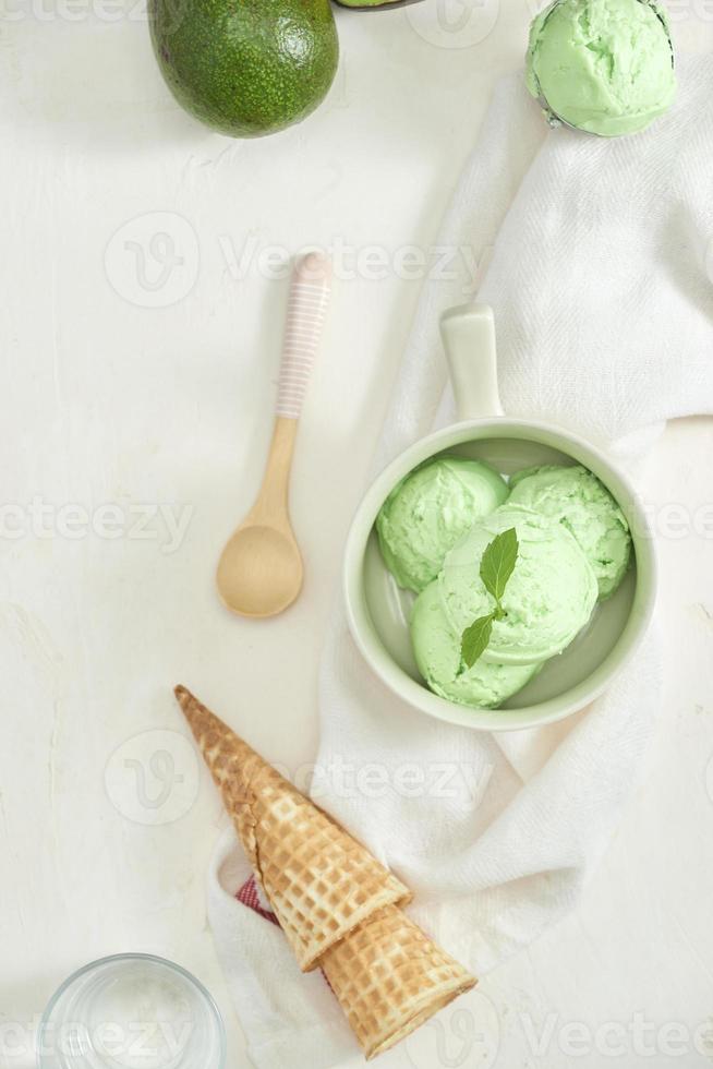 homemade organic avocado ice cream, with ice cream cones. On a grey