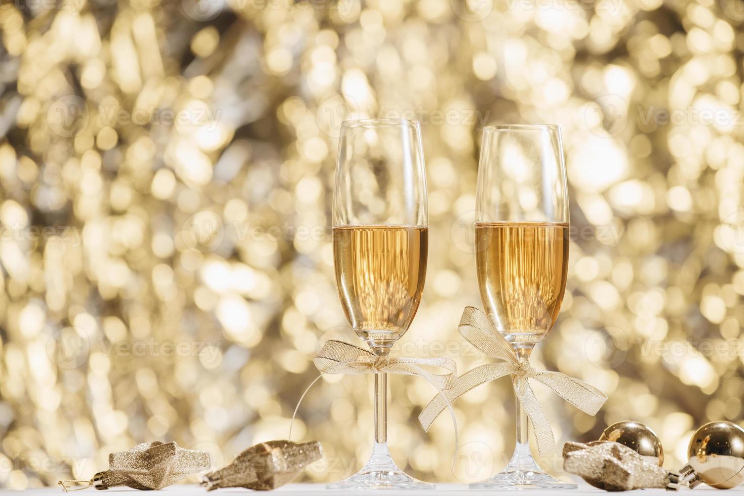 Two full champagne glasses with bokeh lights in the background photo