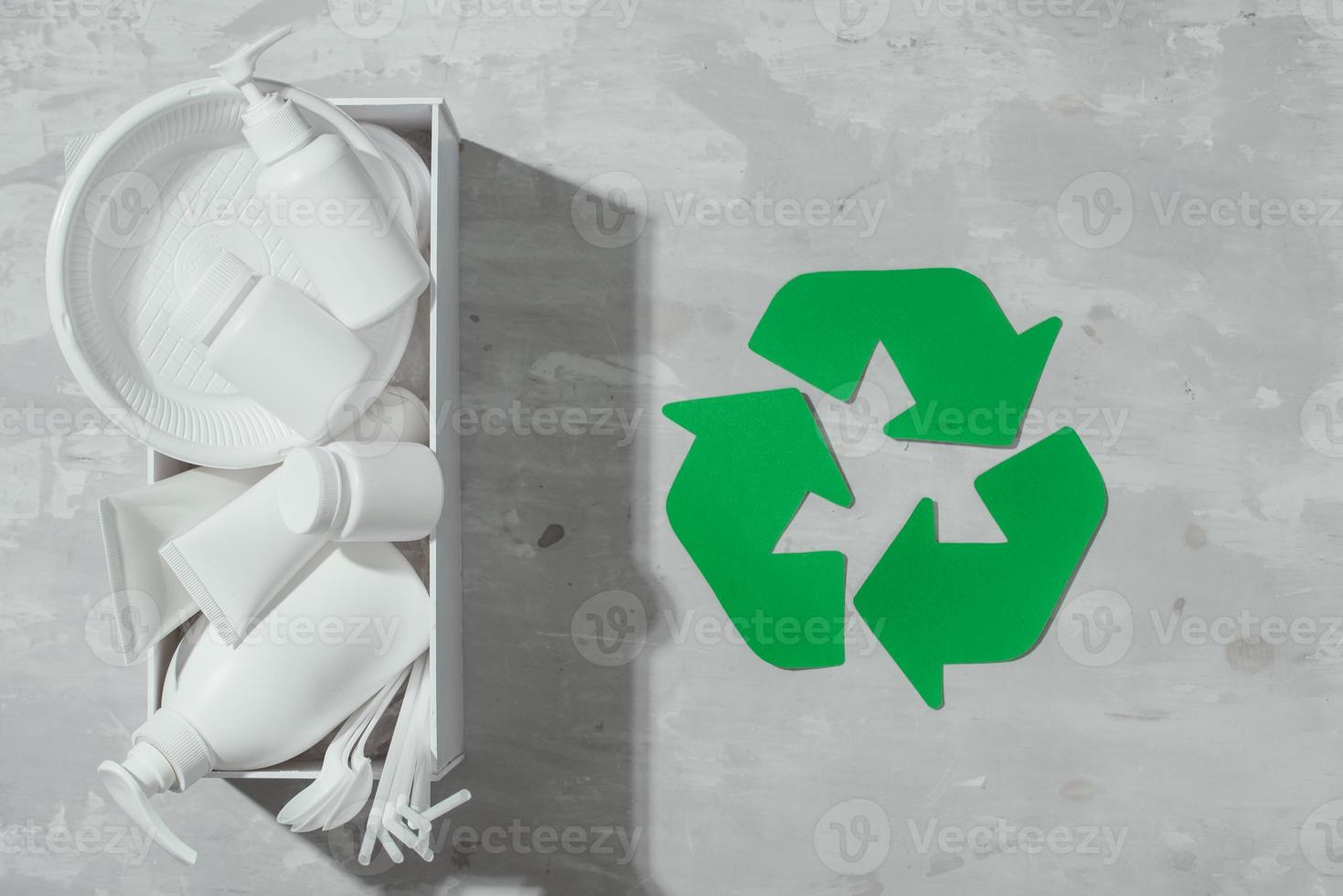 waste recycling eco symbol with garbage disposal on stone table background top view photo