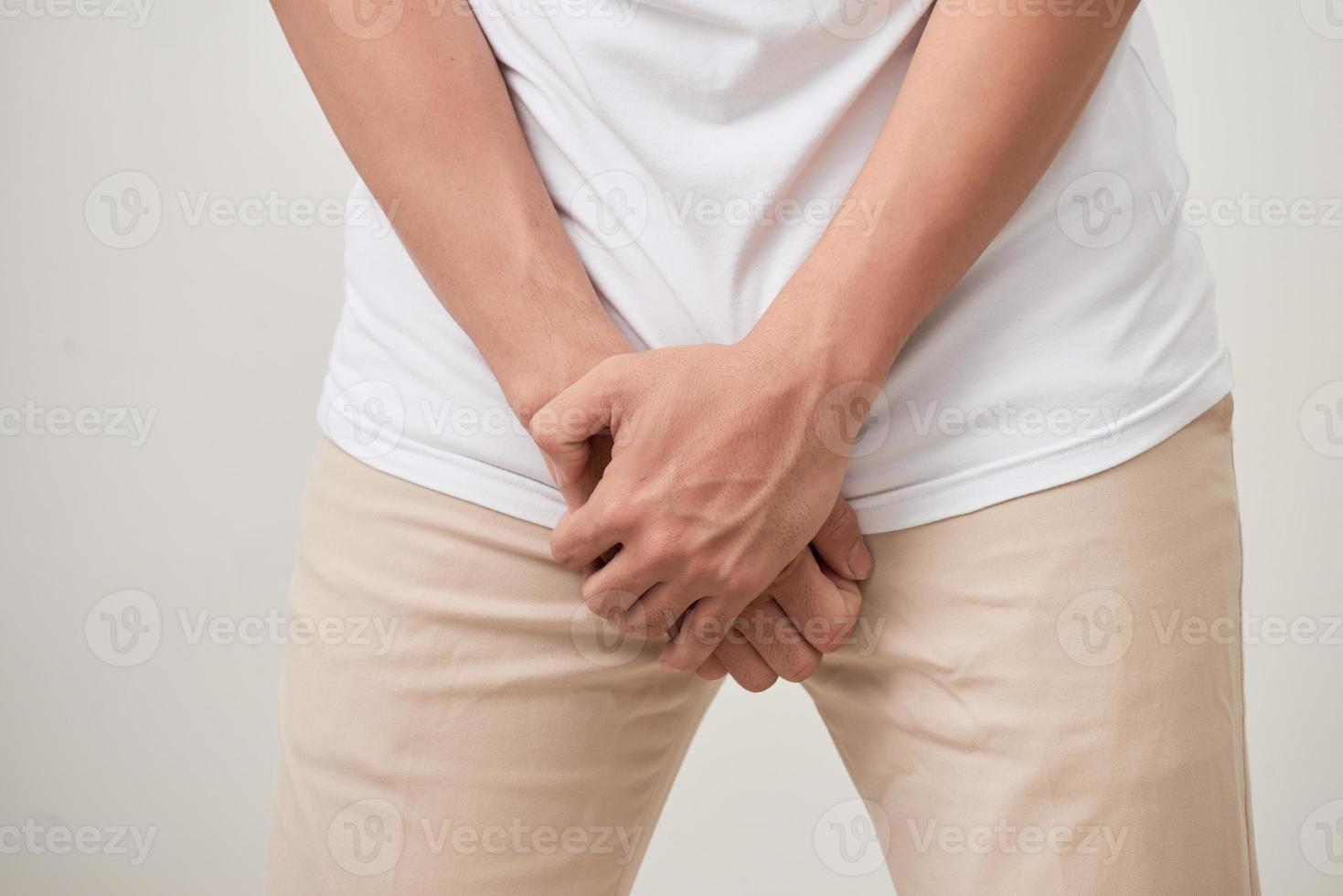 Pain in prostate, man suffering from prostatitis or from a venereal disease, studio shot on white background photo