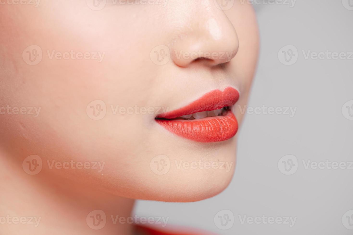 vista de cerca de los labios de una mujer hermosa con lápiz labial mate coral foto