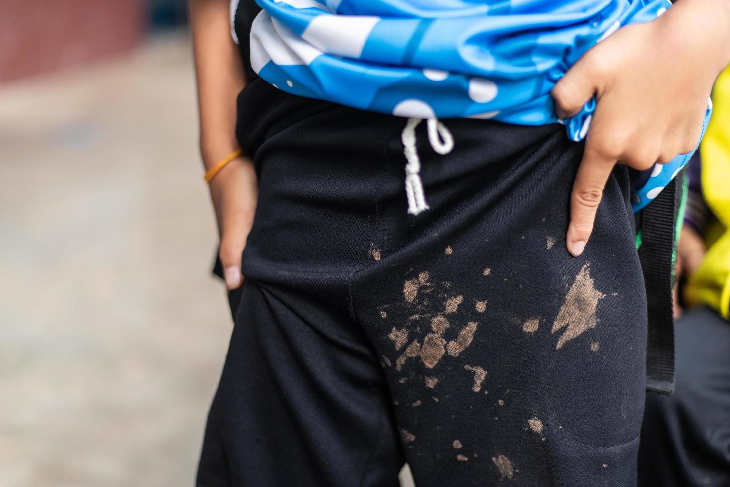 mancha de barro sucio en los pantalones de los niños por jugar mucho en la actividad de la vida diaria. mancha sucia por concepto de limpieza. foto