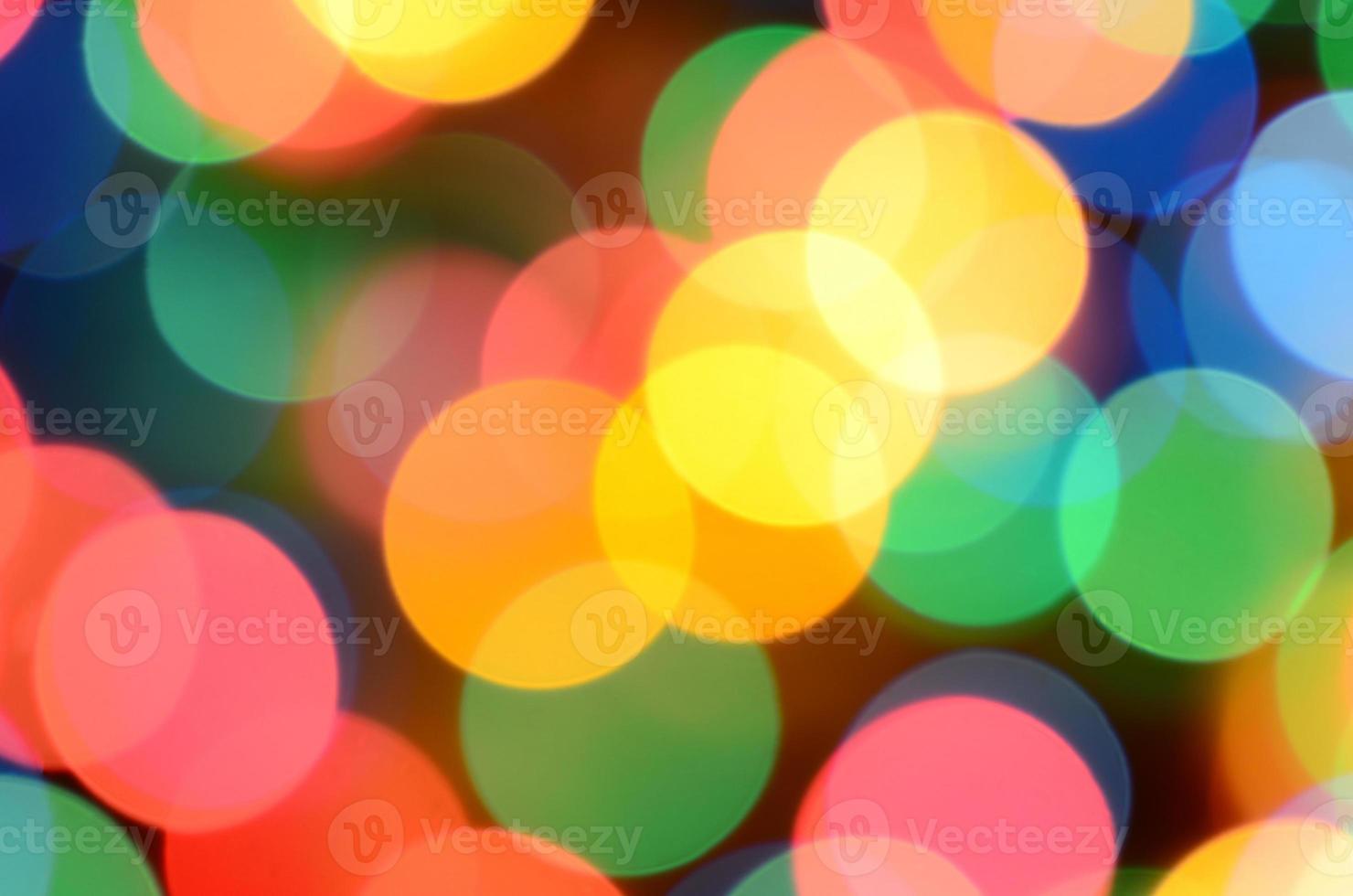 luces de colores festivos borrosos sobre negro útil como fondo. todos los colores principales incluidos. rojo, amarillo, verde y azul foto
