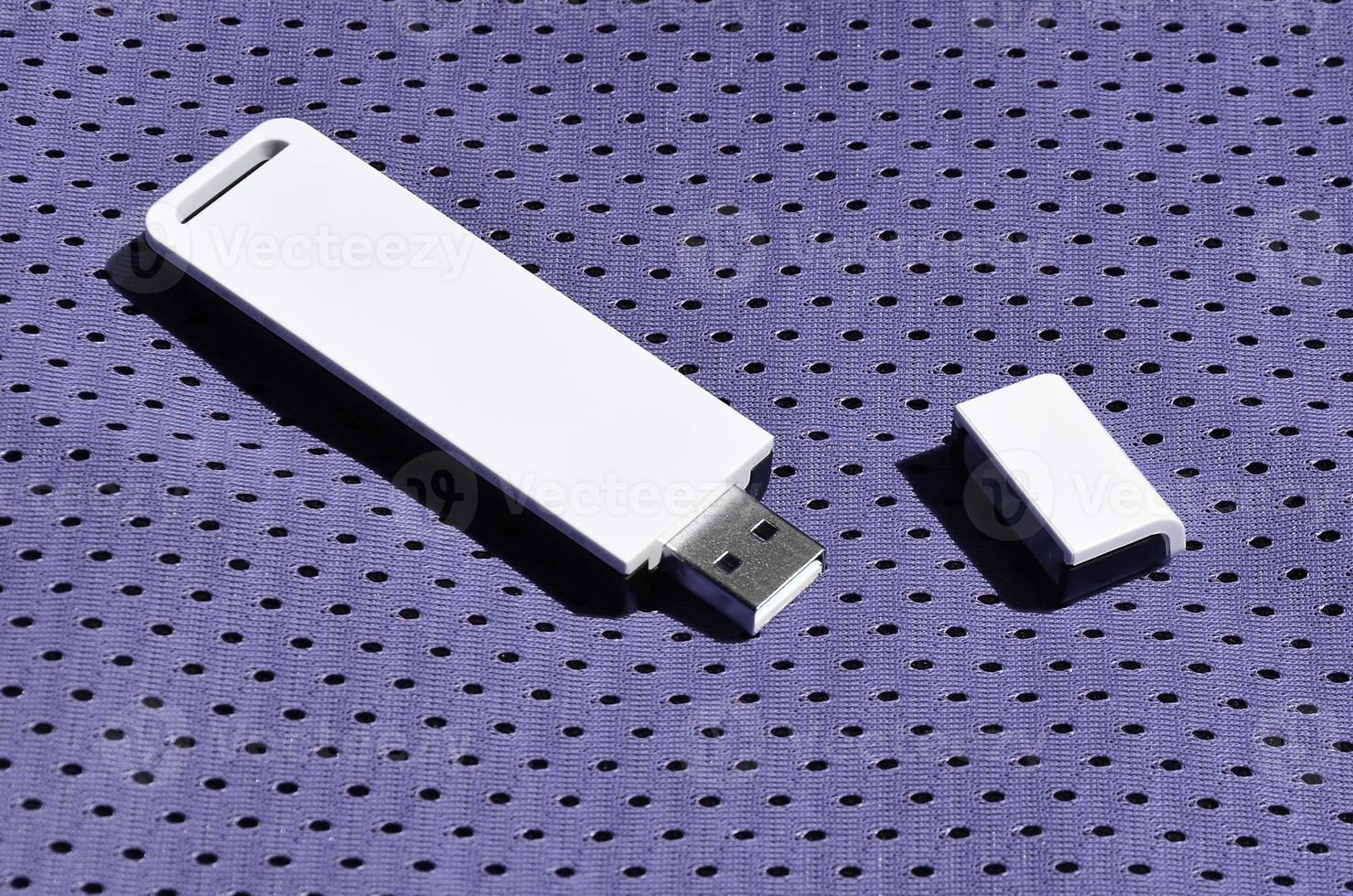 A modern portable USB wi-fi adapter is placed on the violet sportswear made of polyester nylon fiber photo