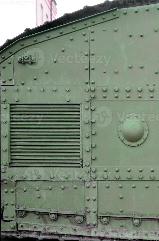 Texture of tank side wall, made of metal and reinforced with a multitude of bolts and rivets photo