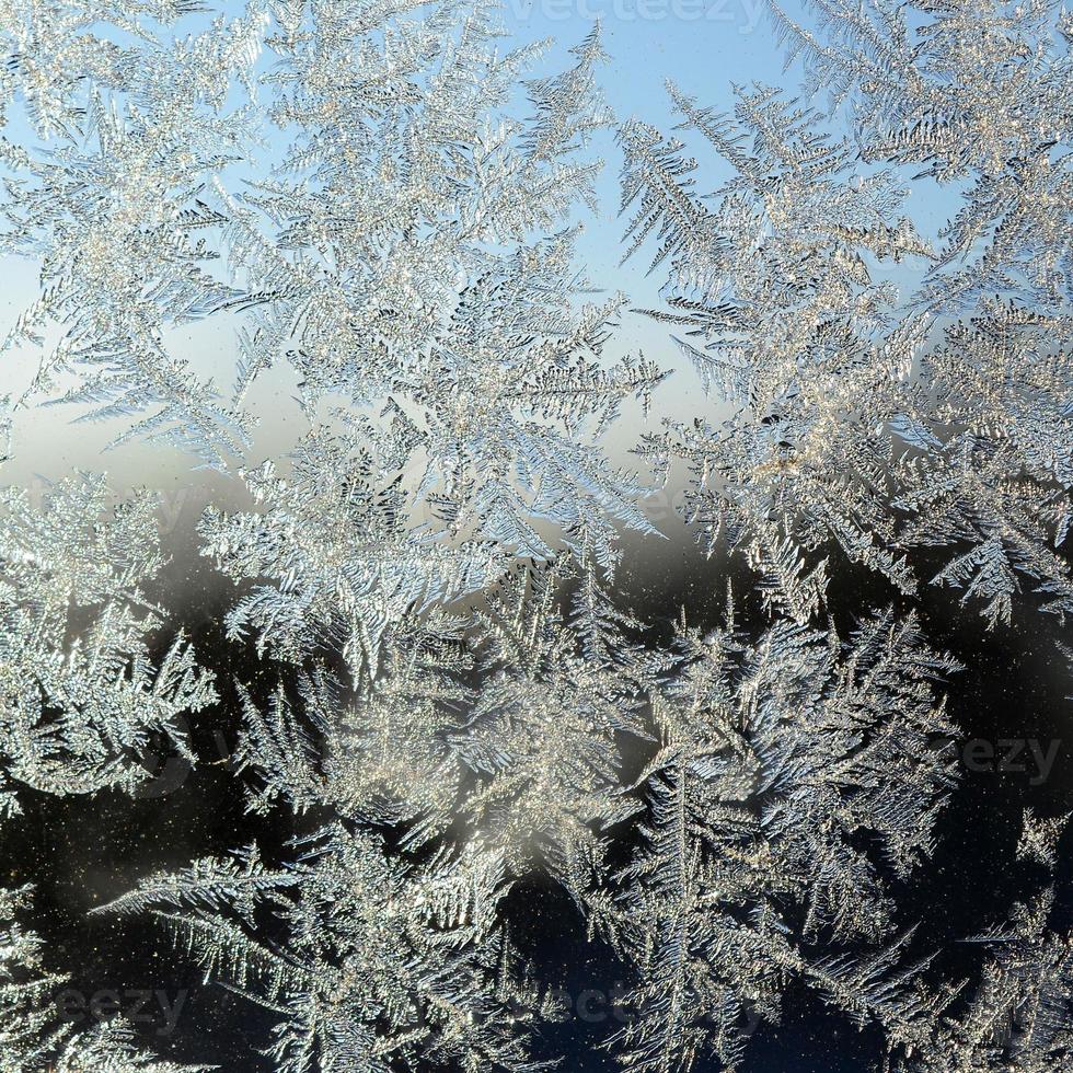 Snowflakes frost rime macro on window glass pane photo