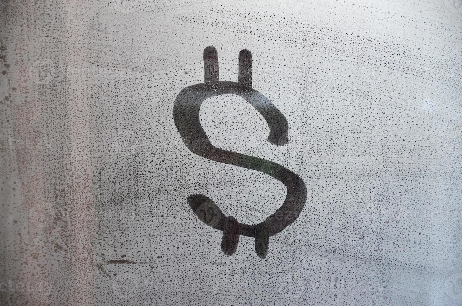 The dollar symbol on the misted sweaty glass. Abstract background image. US money concept photo
