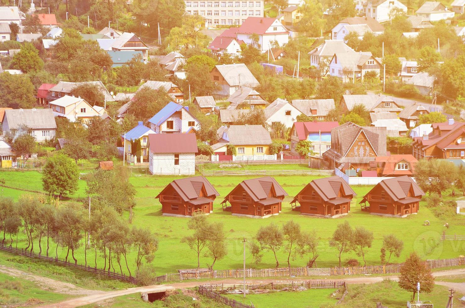 A beautiful view of the village of Mezhgorye, Carpathian region. A lot of residential buildings surrounded by high forest mountains and long river photo