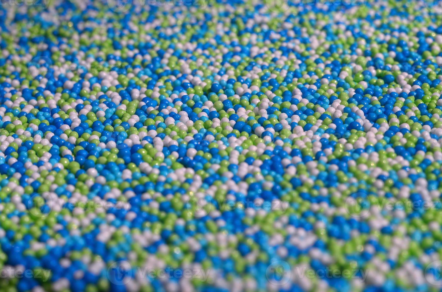 Background picture of a variety of colored glazed powder in the form of small balls photo