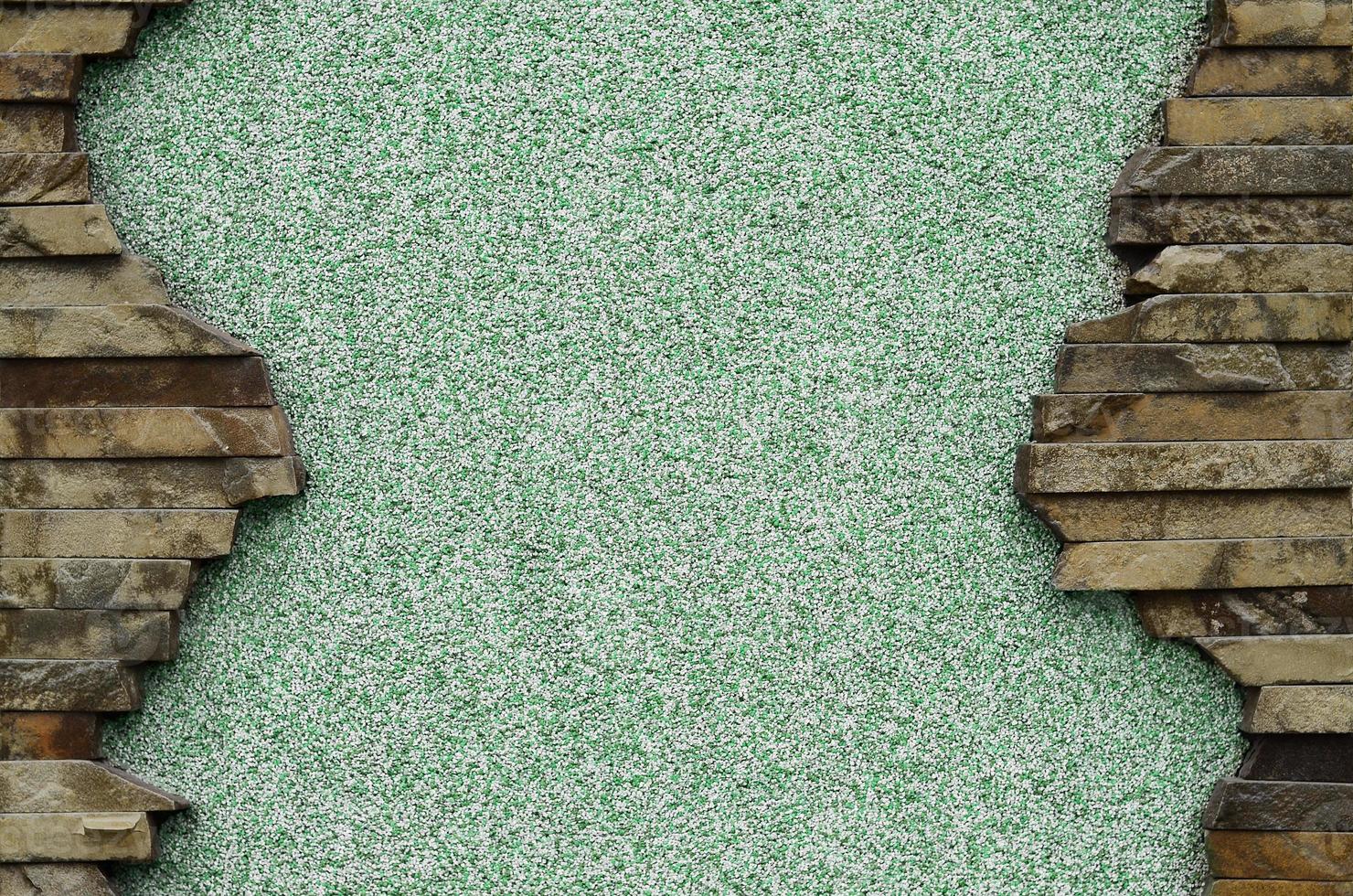 Plastered concrete wall with a frame of flat stones photo