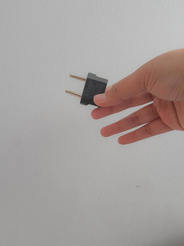 A hand is holding a travel adapter converter photo